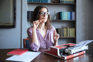 Servicios editoriales para publicar un libro profesionalmente con manuscritos y laptop